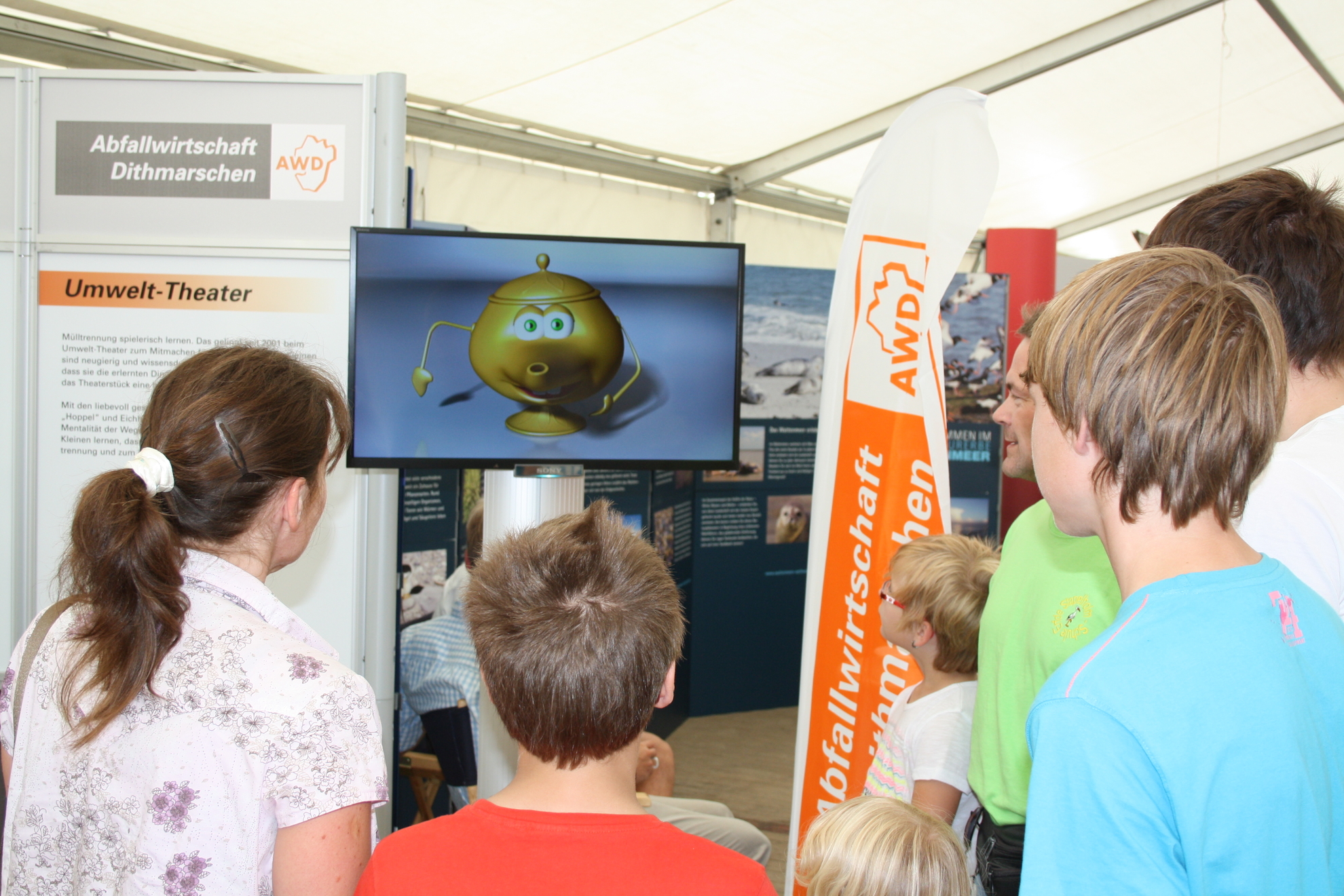 Kinder schauen auf einem Monitor am AWD-Stand den ALADIN-Film nit Winnie, der Wunderlampe.