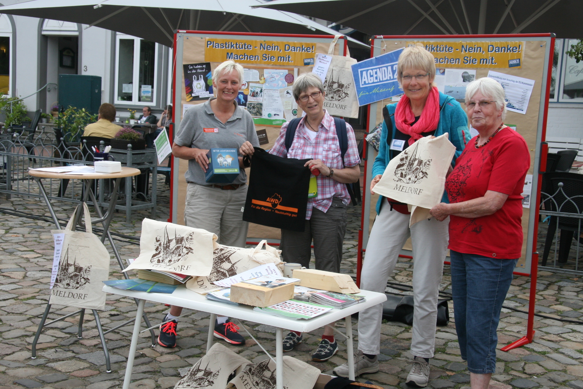 Vier Frauen präsentieren Jute-Beutel an ihrem Stand in Meldorf.