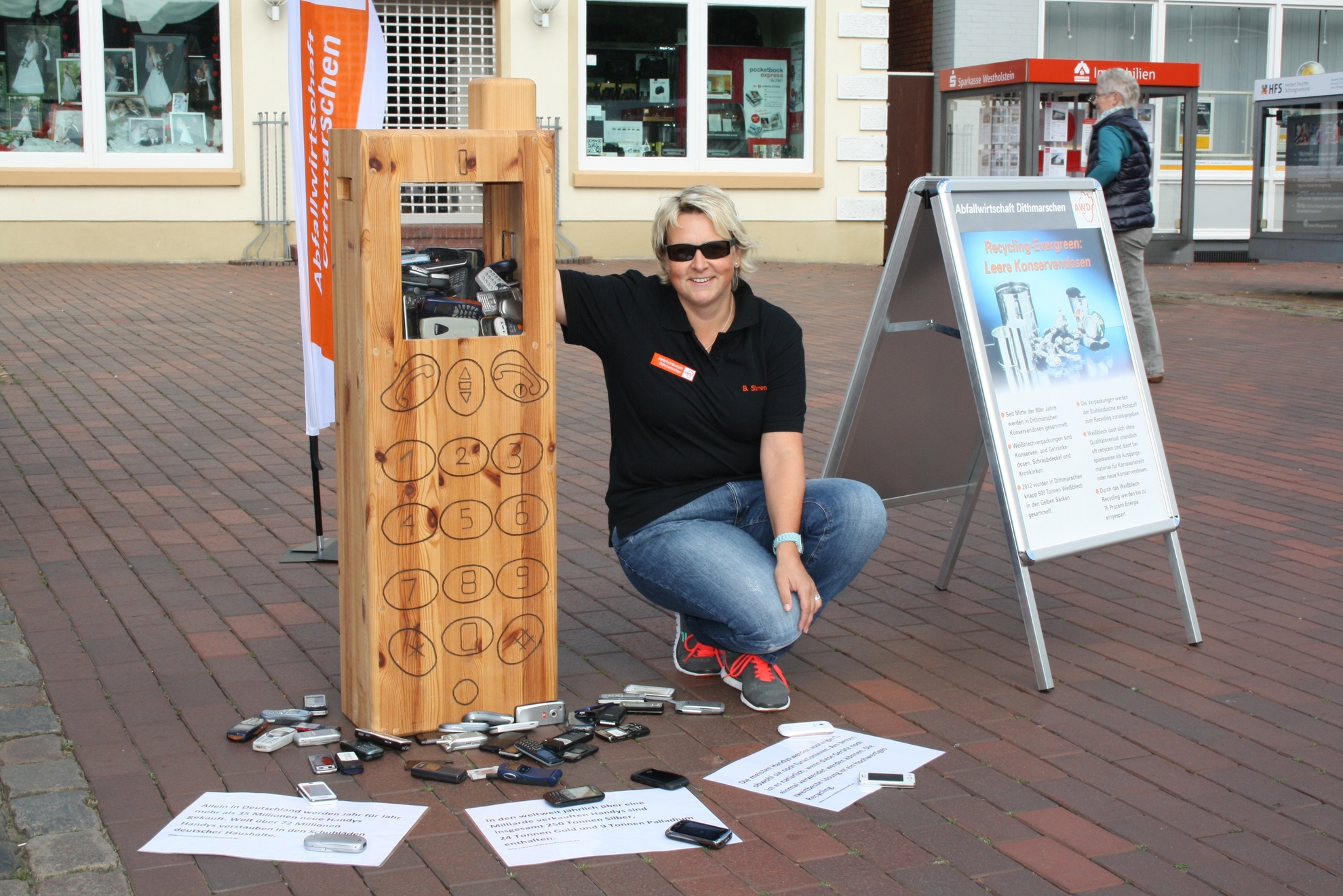 Birgit Siemen (AWD) am AWD-Stand mit einem großen Handy aus Holz.