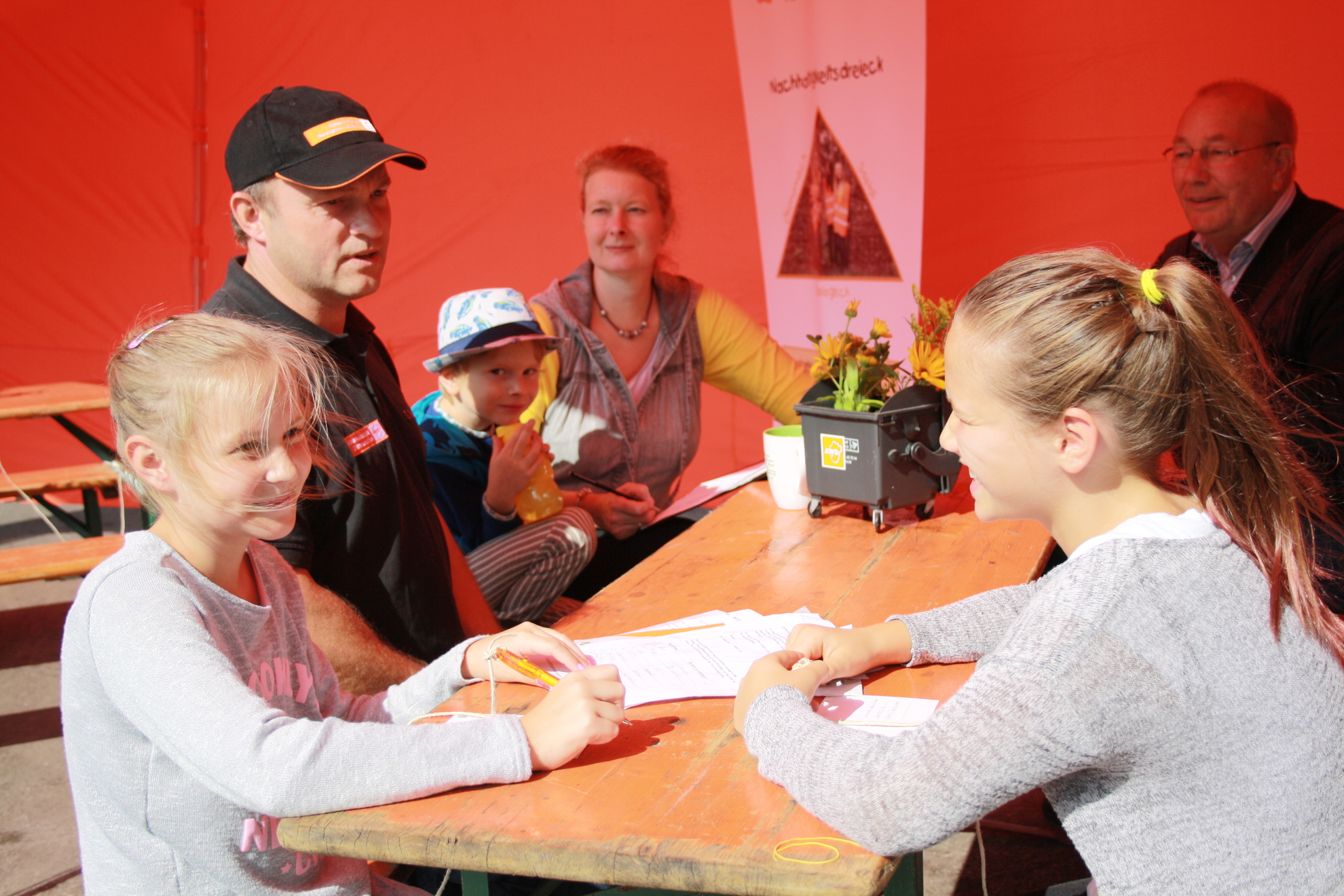 Kinder und Erwachsene sitzen im AWD-Zelt.