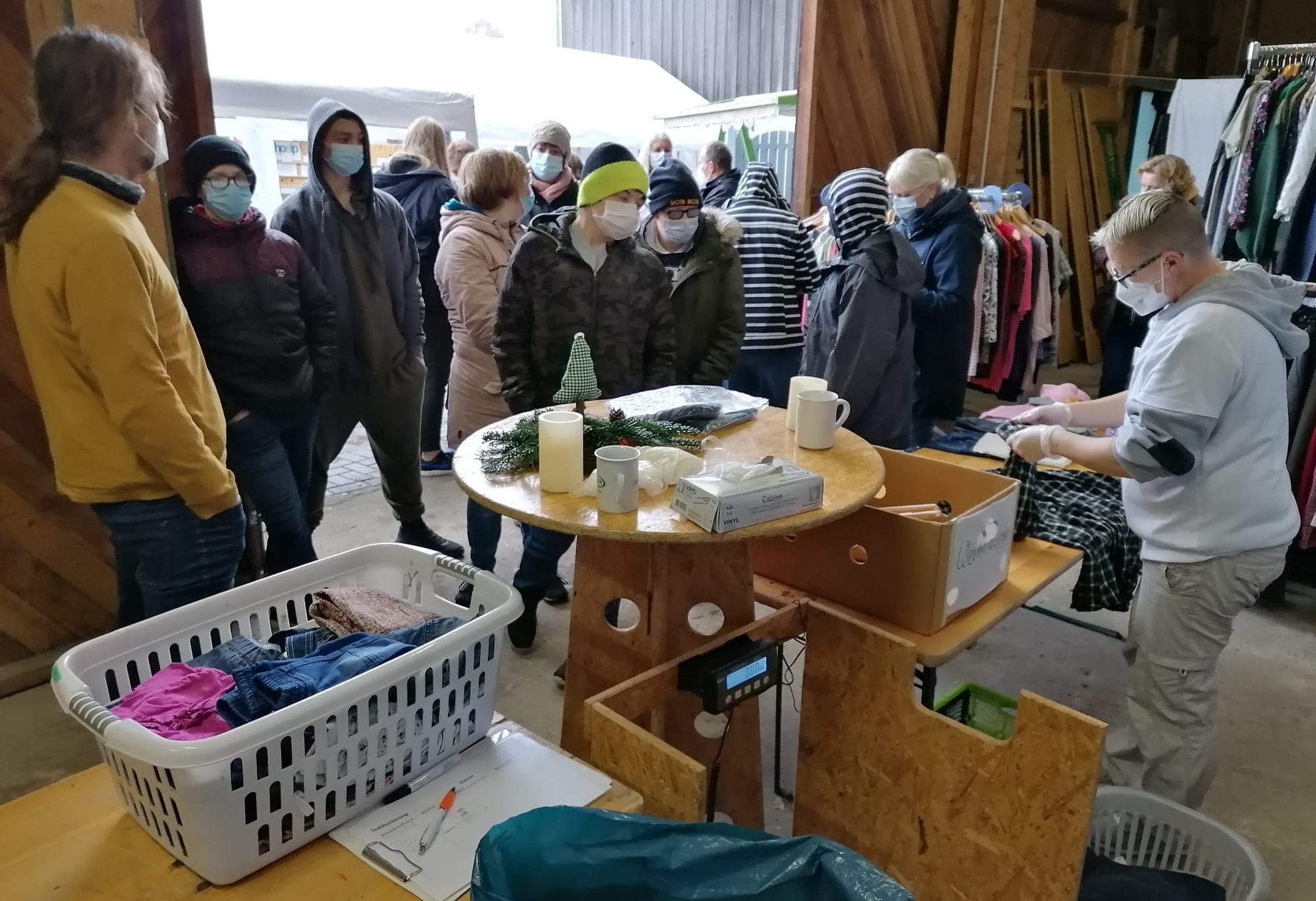 Astrid Lindgren Schule Menschengruppe schaut sich nach Kleidung um.