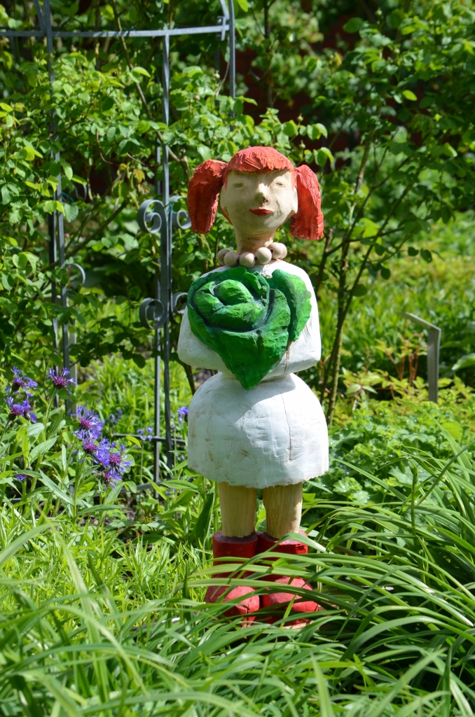 Skulptur im Garten: Frau mit roten Haaren.