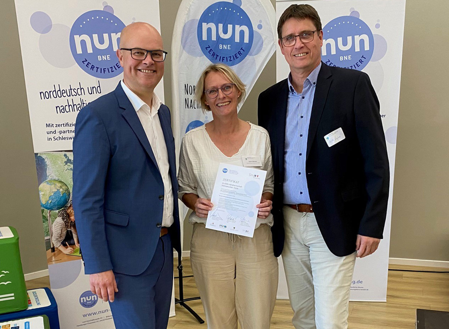 Der Umweltminister Tobias Goldschmidt überreicht AWD-Umweltbildnerin Katrin Martens und AWD-Geschäftsführer Dirk Sopha ein Zertifikat